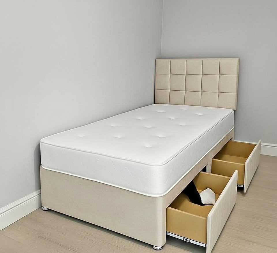 Cream divan bed with upholstered headboard and open storage drawers